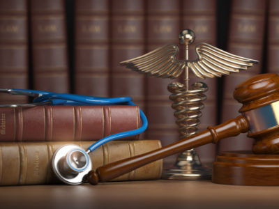 Orthopedic Treatment: Personal Injury Victims - Gavel, stethoscope and caduceus sign on books background. Medic