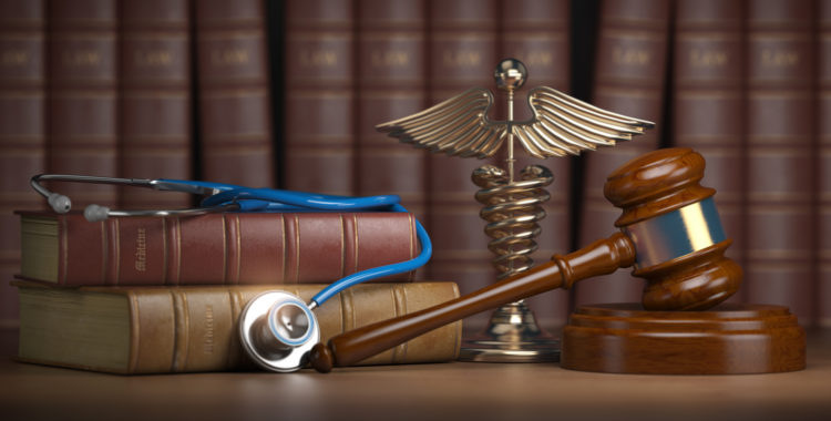 Orthopedic Treatment: Personal Injury Victims - Gavel, stethoscope and caduceus sign on books background. Medic